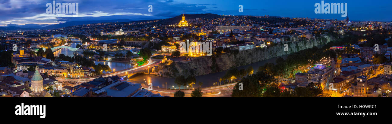 Tbilisi, Georgia. La Scenic panoramica Cima vista del paesaggio urbano in serata illuminazione brillante con tutti i famosi punti di riferimento e attrazioni in drammatico blu C Foto Stock