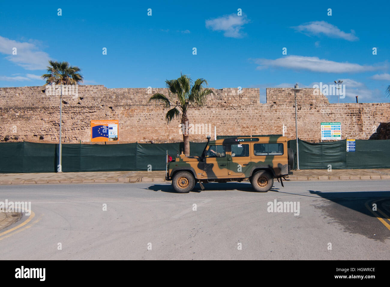 Una vettura militare passa accanto alle antiche mura di Famagosta, la parte settentrionale di Cipro. Foto Stock