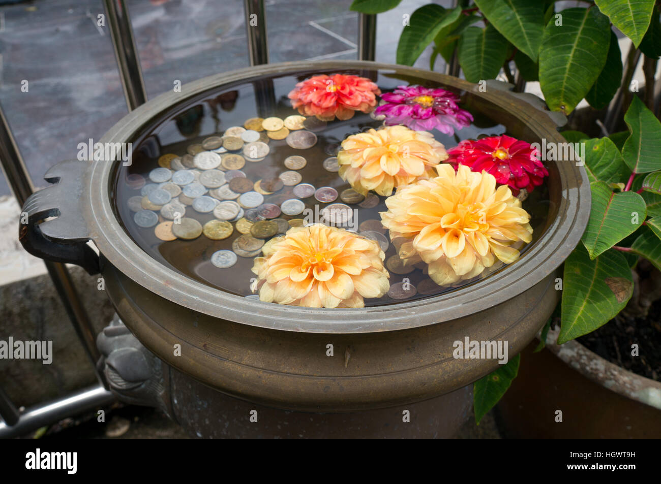 Un piccolo floral Wishing Well con le monete sulla Collina Penang, Malaysia Foto Stock