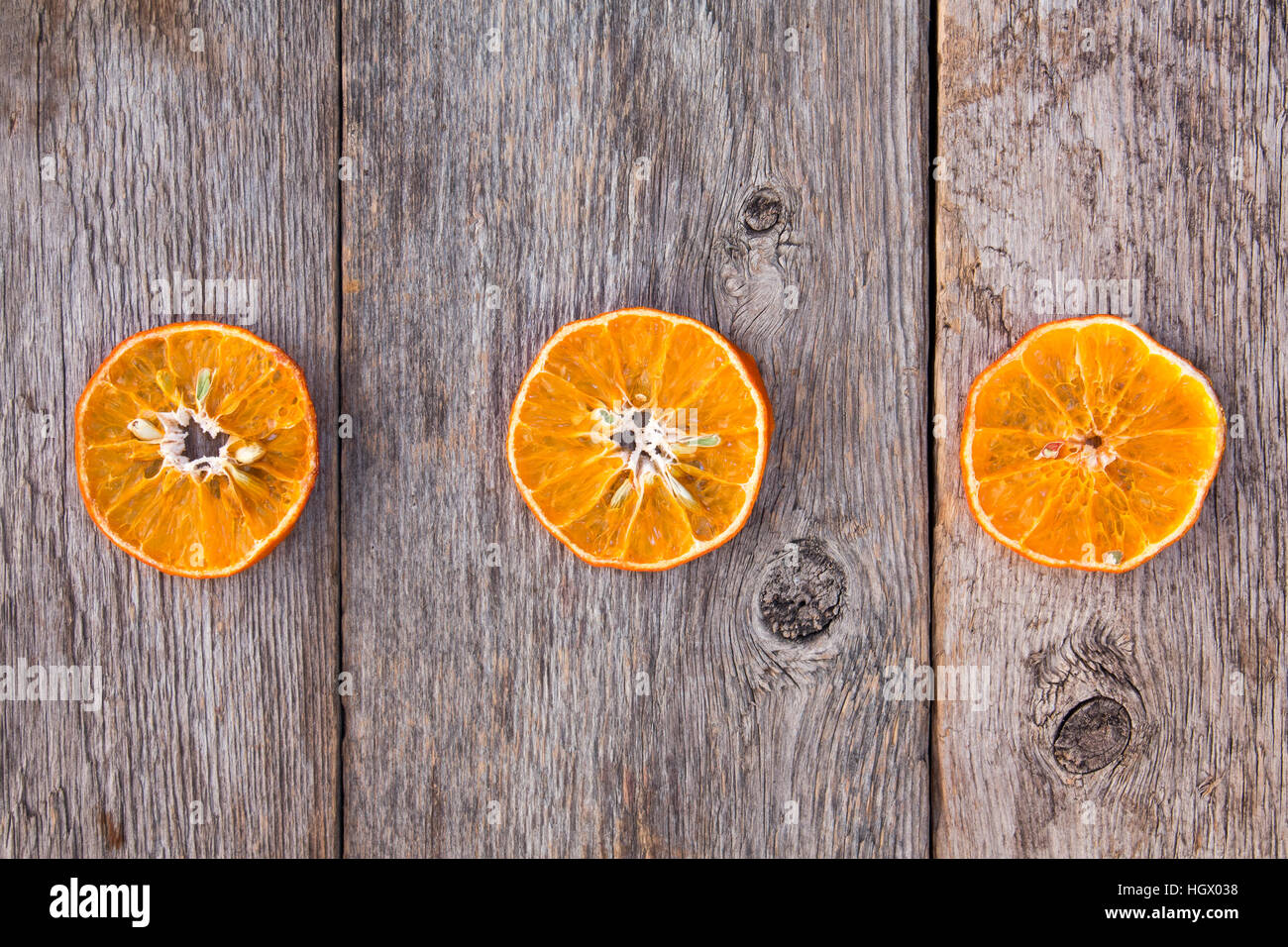 Tre fettine di arancia su uno sfondo di legno. I benefici della frutta. Foto Stock