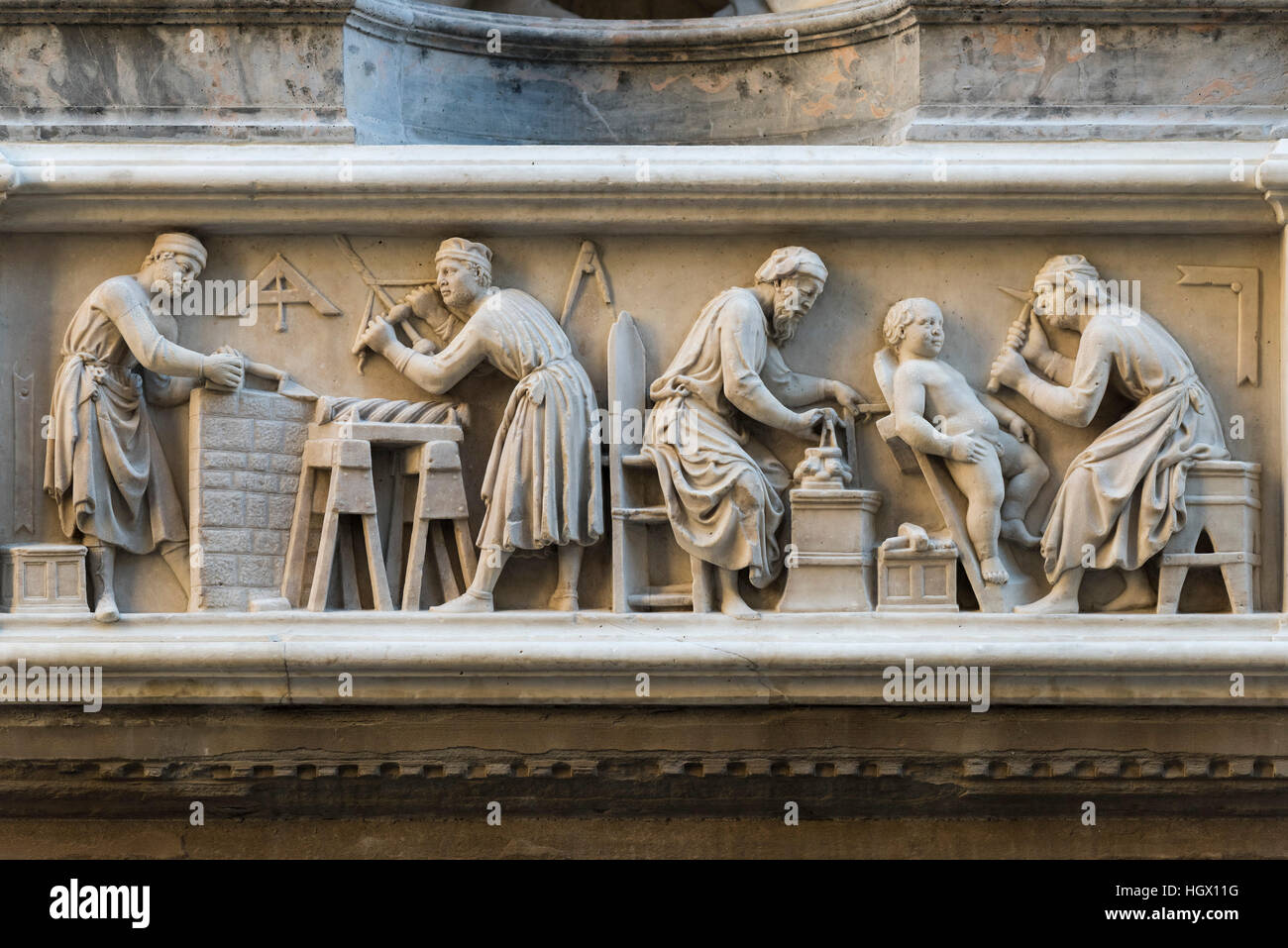 Firenze. L'Italia. Rilievo marmoreo raffigurante muratori, intagliatori del legno e scultori sulla facciata di Orsanmichele. Foto Stock