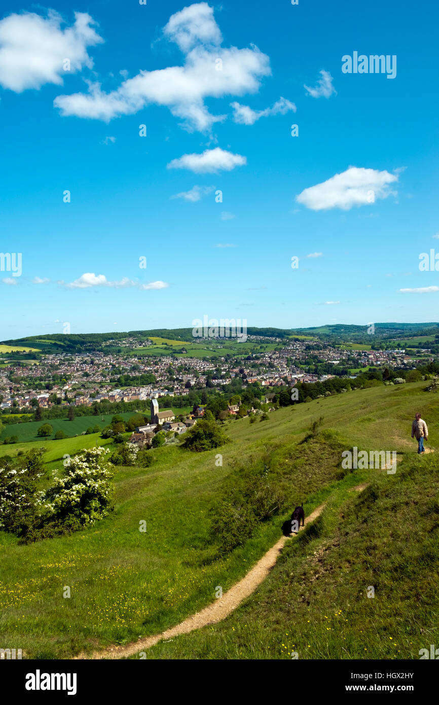 Un uomo cammina un cane a Selsley comune la vista sul villaggio di Selsley e Stroud Valli, Gloucestershire, Cotswolds, REGNO UNITO Foto Stock