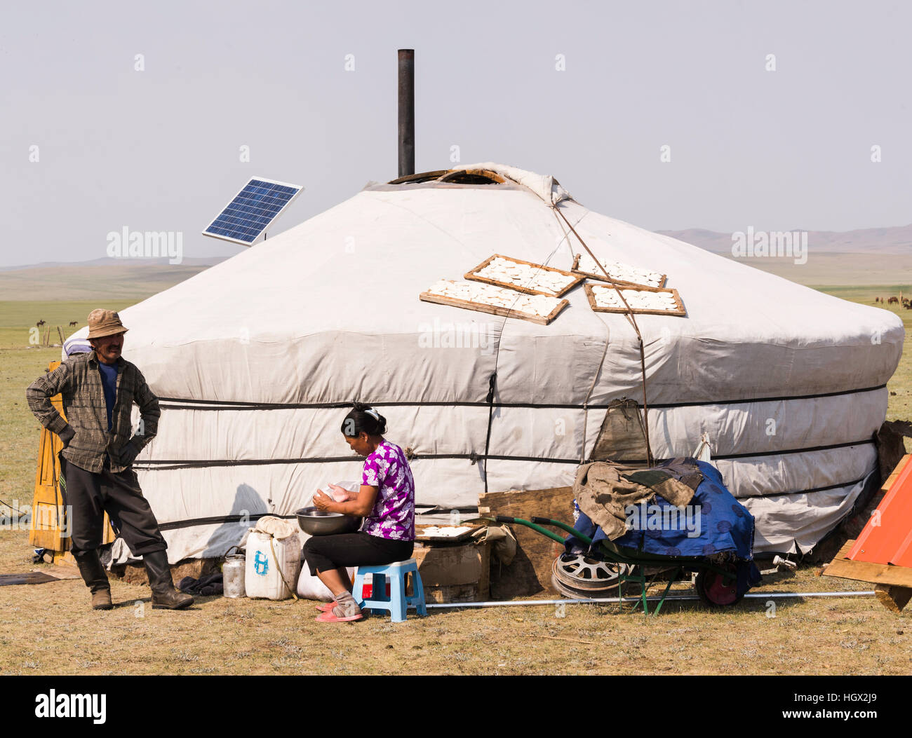 L uomo e la donna al di fuori di un Ger rendendo mares formaggio di latte, Mongolia, Asia Foto Stock