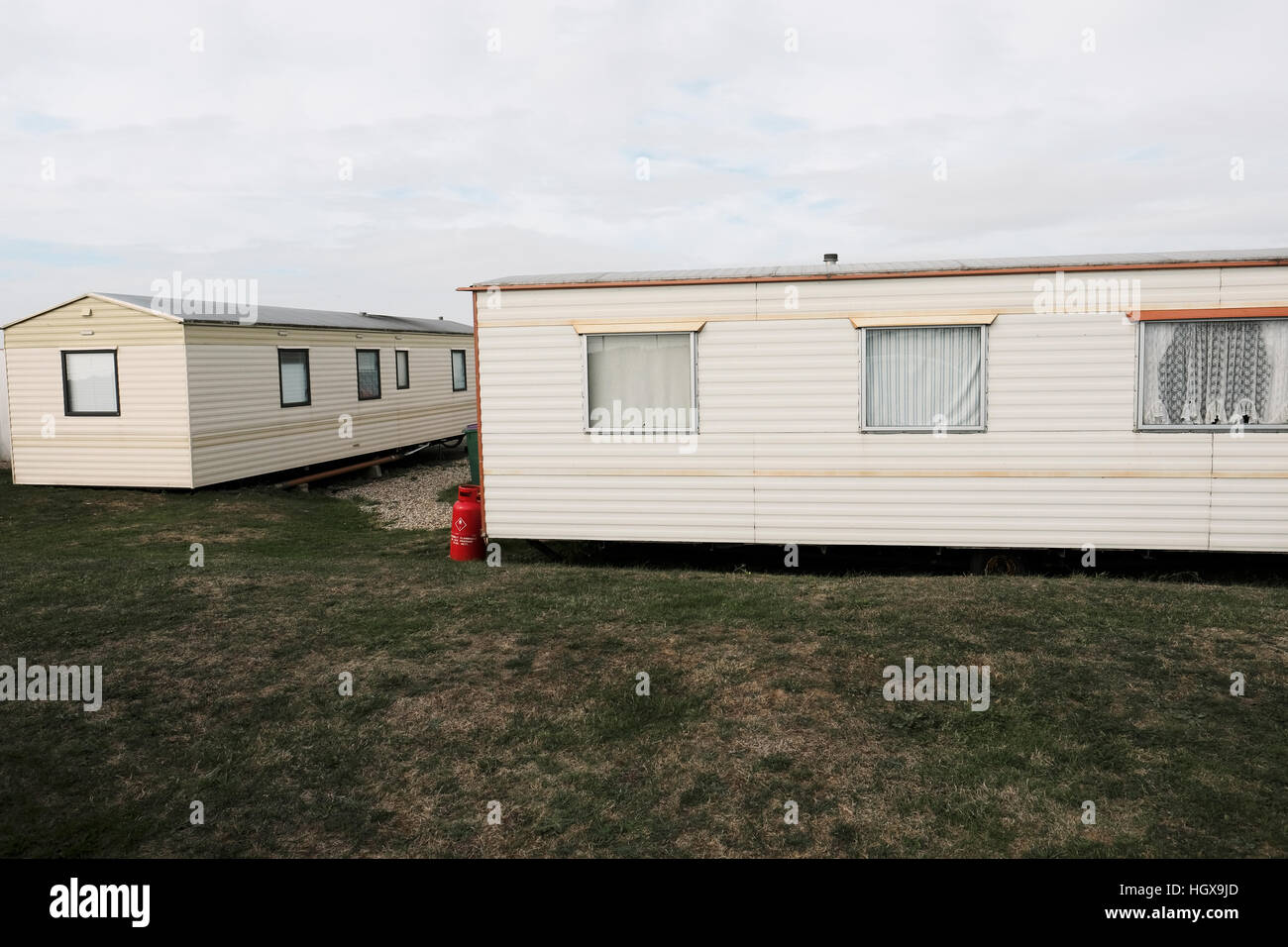 Case mobili in un parco caravan in Inghilterra con bombole di gas rosso esterne Foto Stock