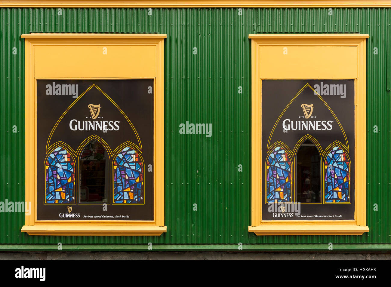 Due finestre di colore giallo con la birra Guinness logo circondato da verdi schierati. Foto Stock