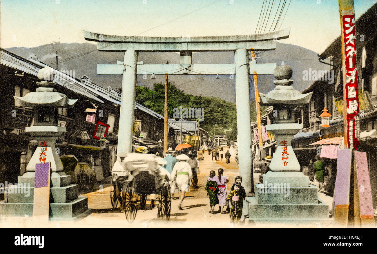 Giappone, Kobe Sannomiya. Cartolina Vintage colorate a mano. Strada di Ikuta santuario con tori e due lanterne di pietra. Sullo sfondo delle montagne. Foto Stock
