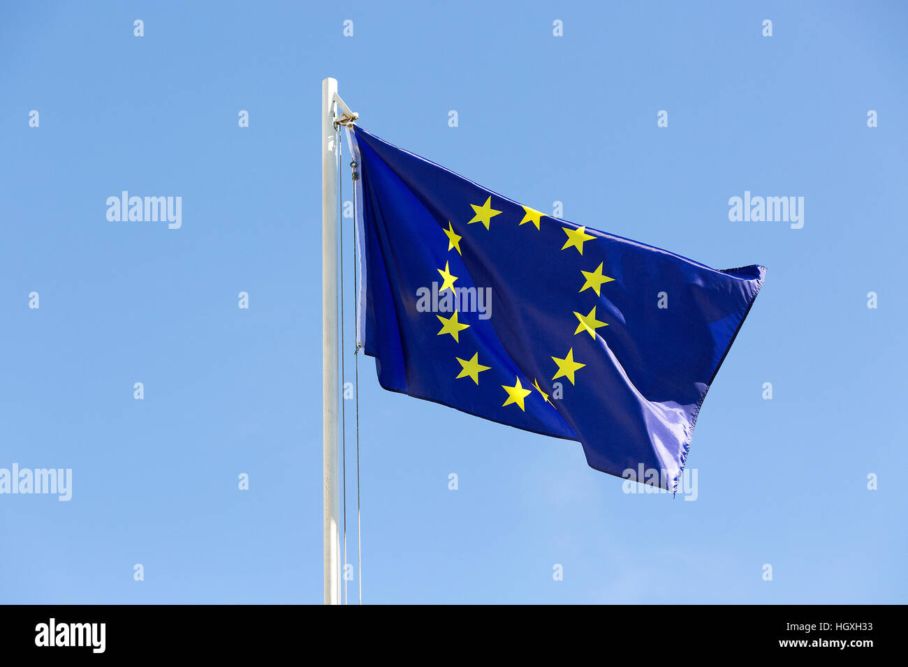 Bandiera dell'Unione europea su un pennone di fronte blu cielo Foto Stock