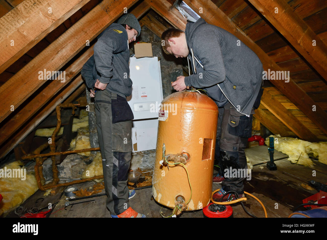 Gli idraulici montaggio nuova caldaia in un loft in una vecchia casa in  Aberdeen Scotland Foto stock - Alamy