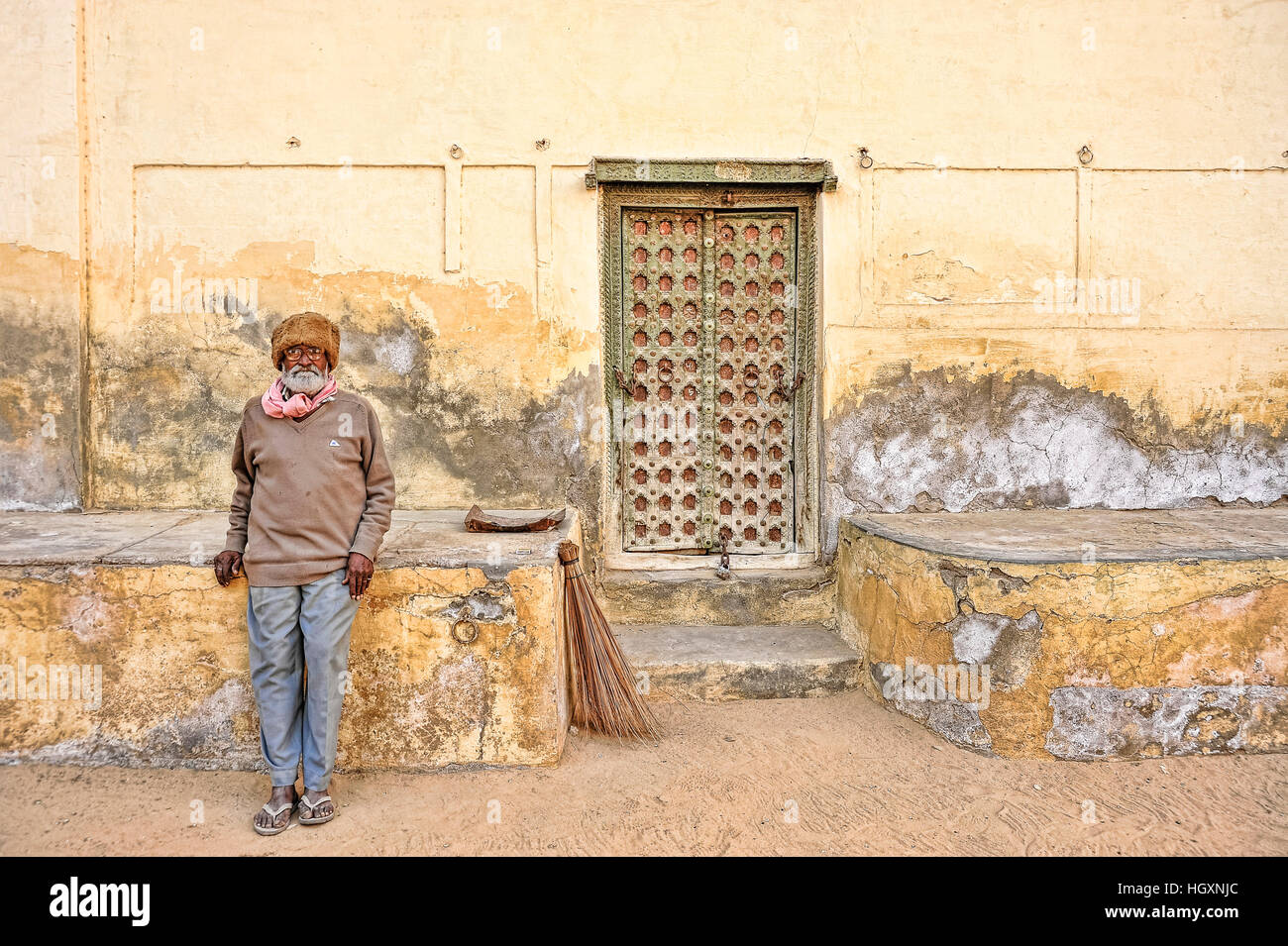 Custode prende una pausa dalle sabbie di spazzamento fuori Mehansar Fort Foto Stock