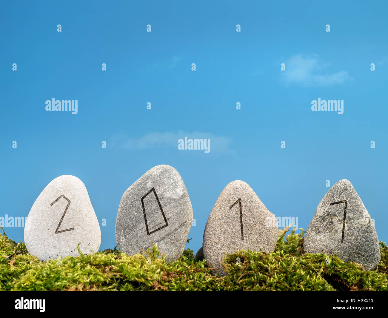 Anno Nuovo 2017 data incisa in quattro pietre runiche in alfabeto stile sul cielo blu Foto Stock