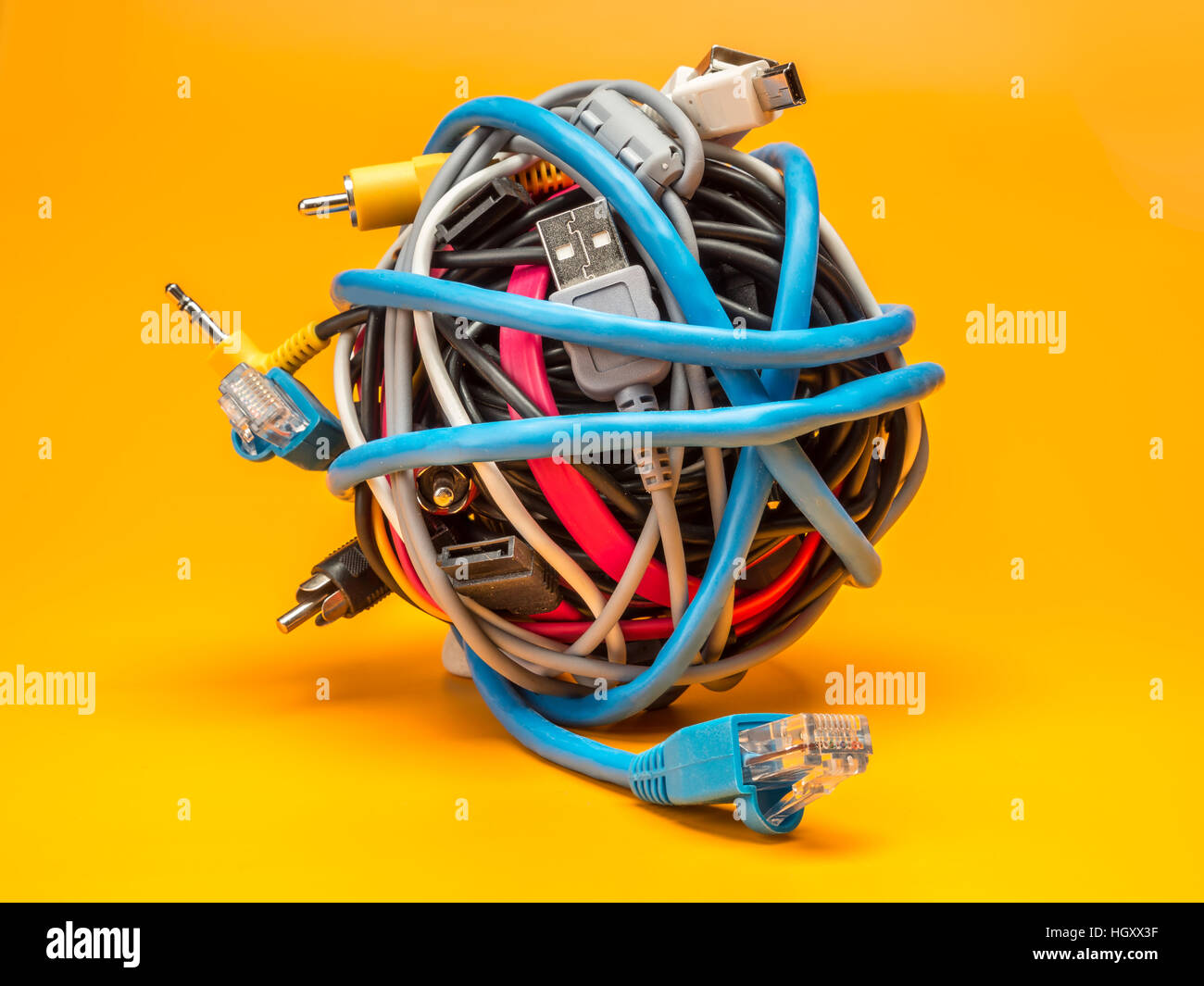 Tangled rotolo di fili di computer su sfondo giallo Foto Stock
