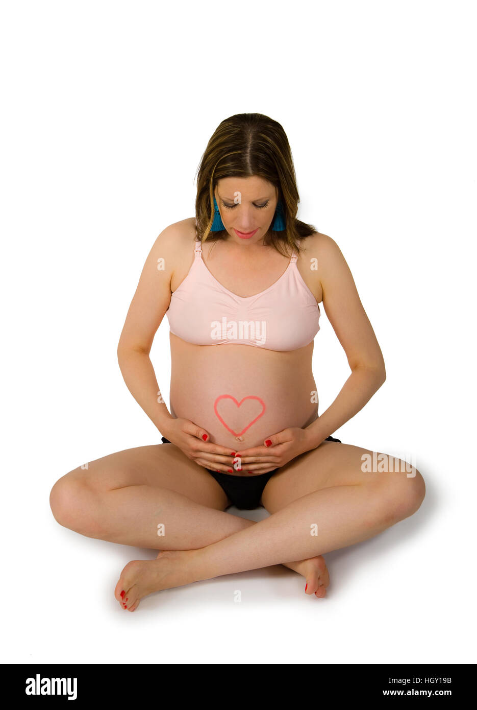 Donna incinta con un cuore scritto con il rossetto sul suo ventre Foto Stock