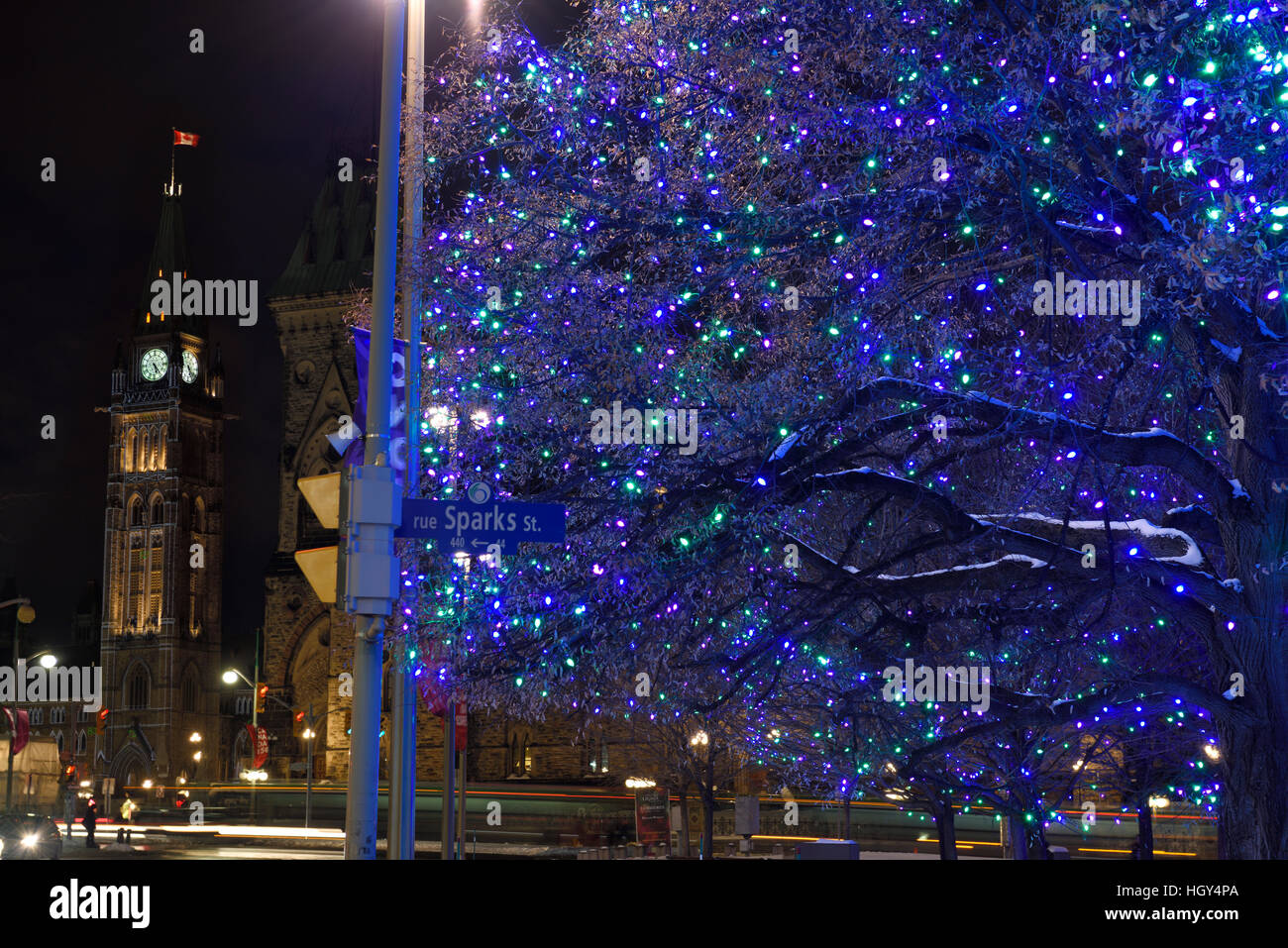 Blu luci di Natale in Piazza della Confederazione a Sparks Street con gli edifici del Parlamento europeo di pace di Ottawa a torre Foto Stock