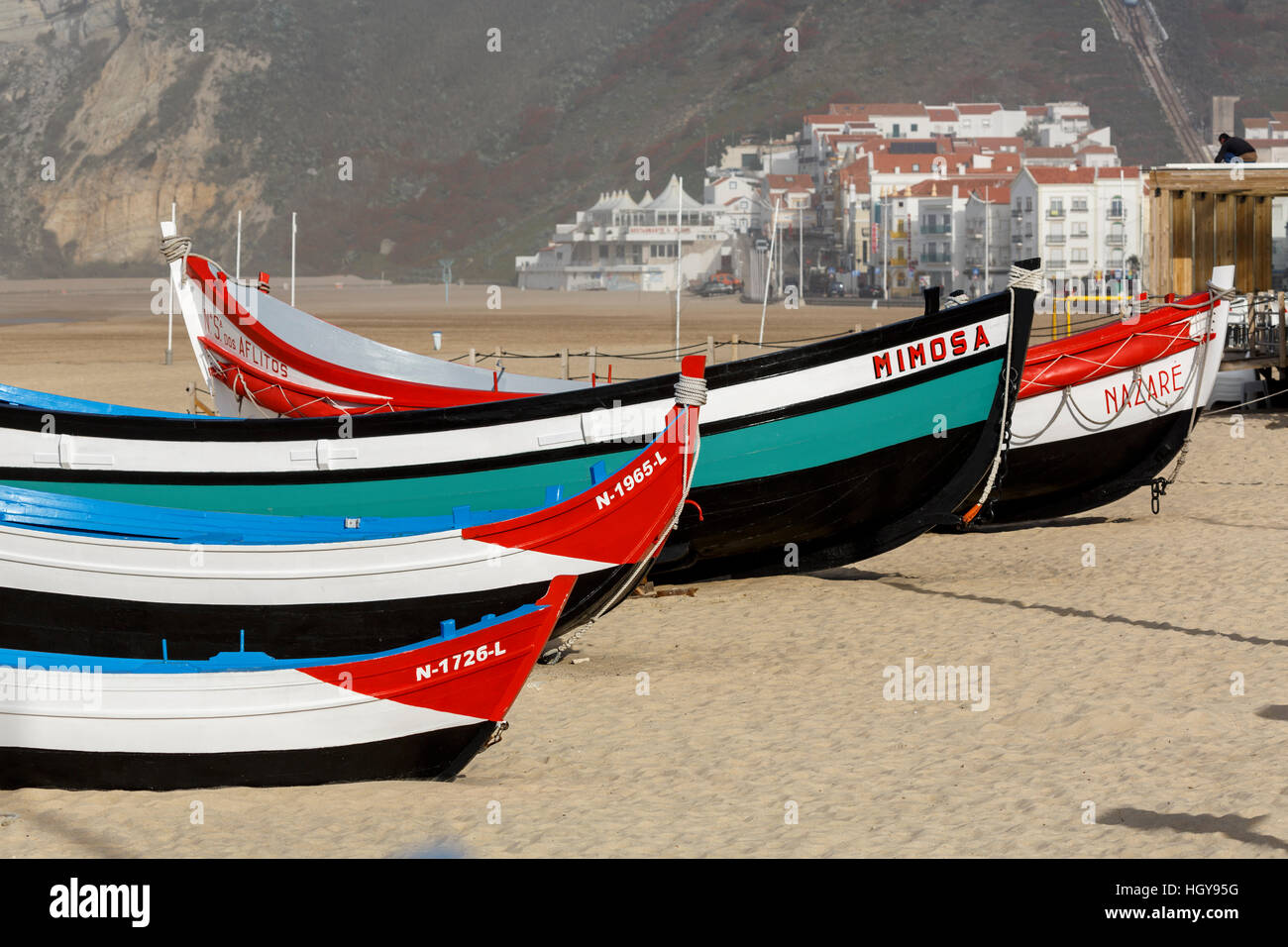 Tradizionale coloratissime barche di pescatori sulla spiaggia di Nazare sulla Costa d'argento o Costa de Prata in Portogallo Foto Stock