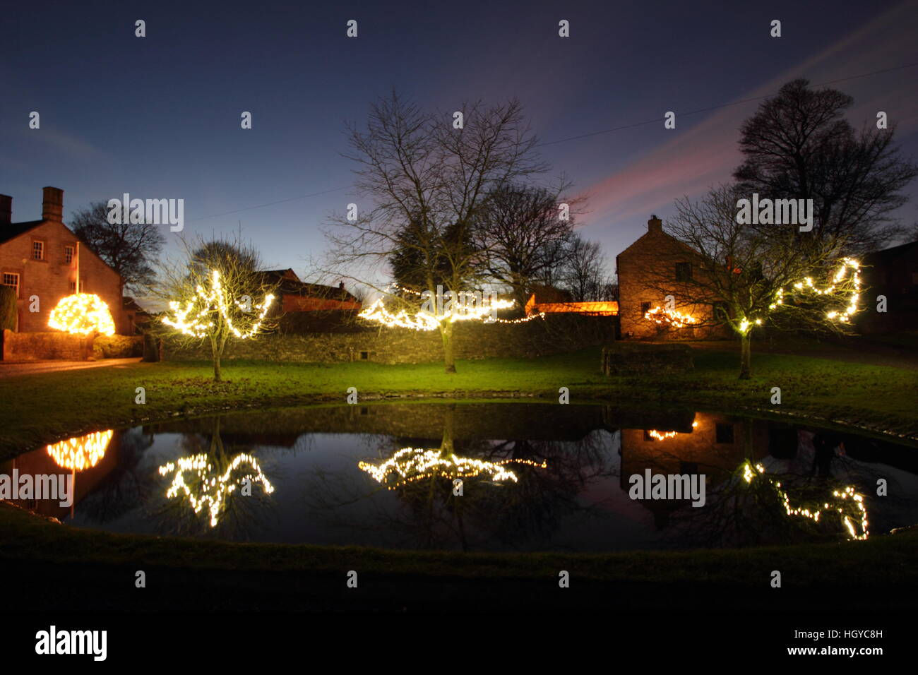 Le luci di Natale intorno al laghetto sul verde in Foolow, Parco Nazionale di Peak District, Derbyshire, England, Regno Unito Foto Stock