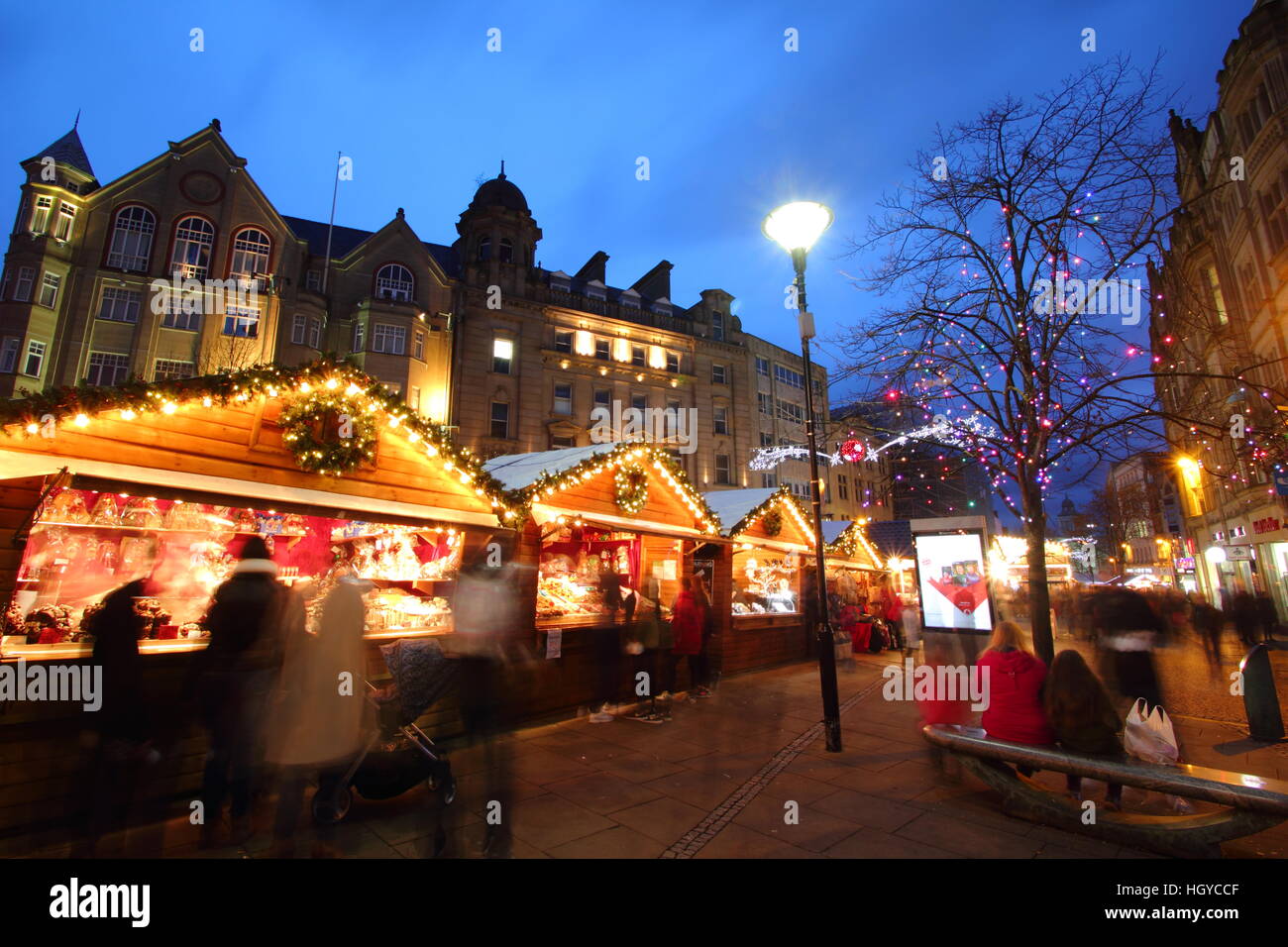 Gli acquirenti di festa sfoglia merci nella cute di cabine di legno al mercatino di Natale sulla Fargate, centro della città di Sheffield nello Yorkshire, Inghilterra Foto Stock
