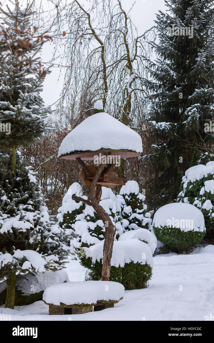 Legno bird feeder, birdhouse installato su giardino d inverno in giornata nevosa Foto Stock