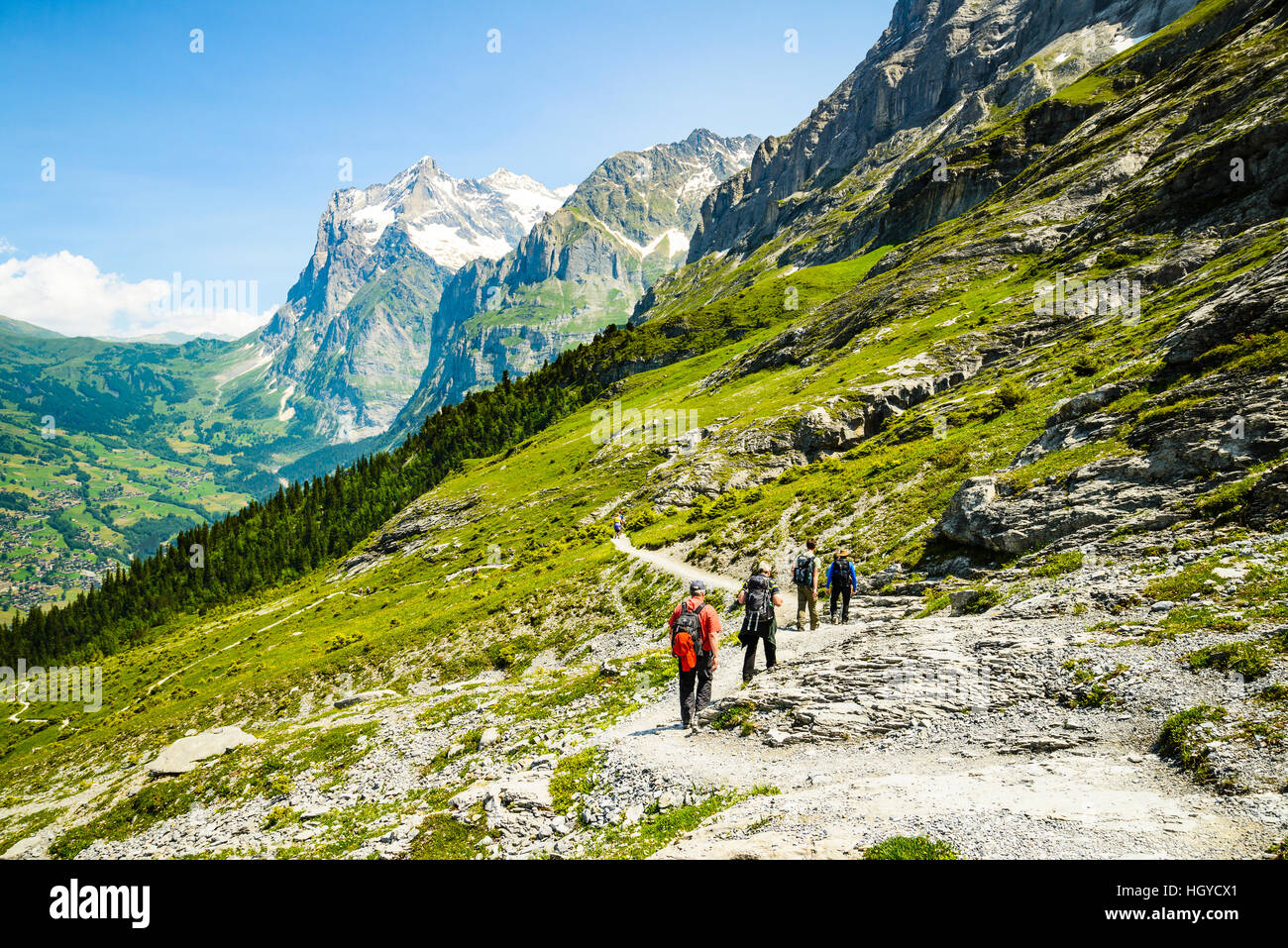 Gli escursionisti sul sentiero di Eiger svizzera con il Grindelwald valle sottostante e il Wetterhorn dietro di picco Foto Stock