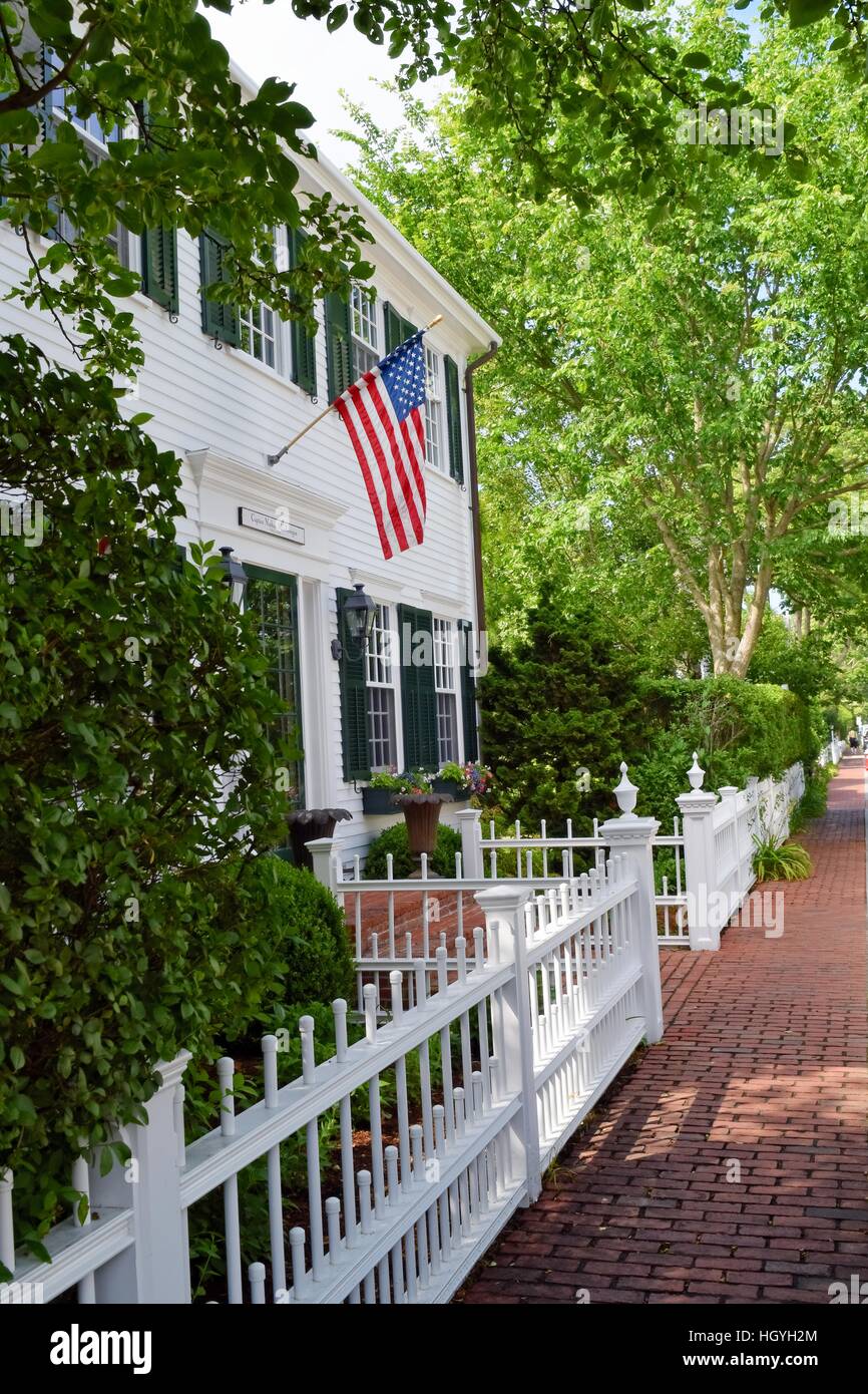 Tradizionale vecchi infissi bianchi New England casa coloniale di Martha's Vineyard, Massachusetts, STATI UNITI D'AMERICA con una bandiera e recinto esterno Foto Stock