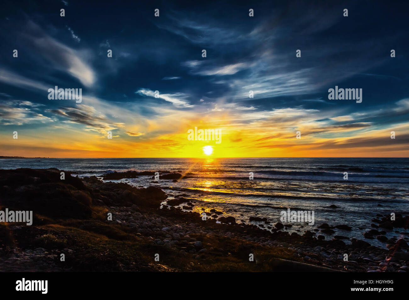 Uno splendido scenario sulla riva del mare, le onde e il tramonto Foto Stock