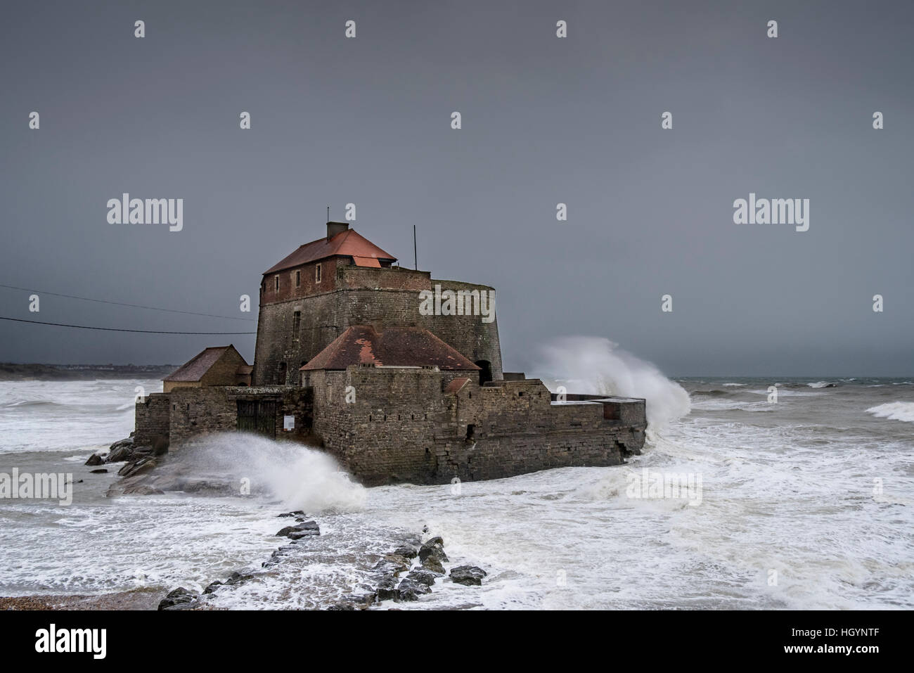 Ambleteuse, Francia. Xiii gen, 2017. Onde che si infrangono contro Vauban's Fort Mahon a Ambleteuse durante la tempesta di neve lungo la costa del Mare del Nord, Côte d'Opale/Opal Coast, Francia. 13 gennaio, 2017 © Arterra Picture Library/Alamy Live News Foto Stock