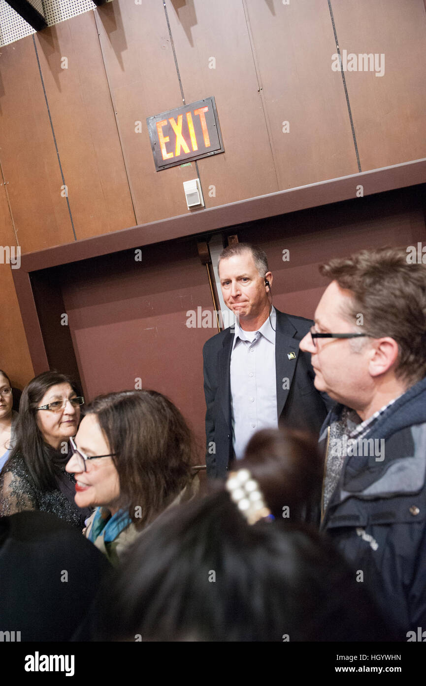 London, Ontario, Canada, 13 gennaio, 2017. Un agente di sicurezza sta di guardia di fronte a una porta di uscita nella sala degli alumni della London University of Western Ontario, dove il primo ministro del Canada, stava partecipando a un municipio Q&A. Londra è stata quella del primo ministro si ferma come parte del suo cross-country tour. Credito: Rubens Alarcon/Alamy Live News Foto Stock