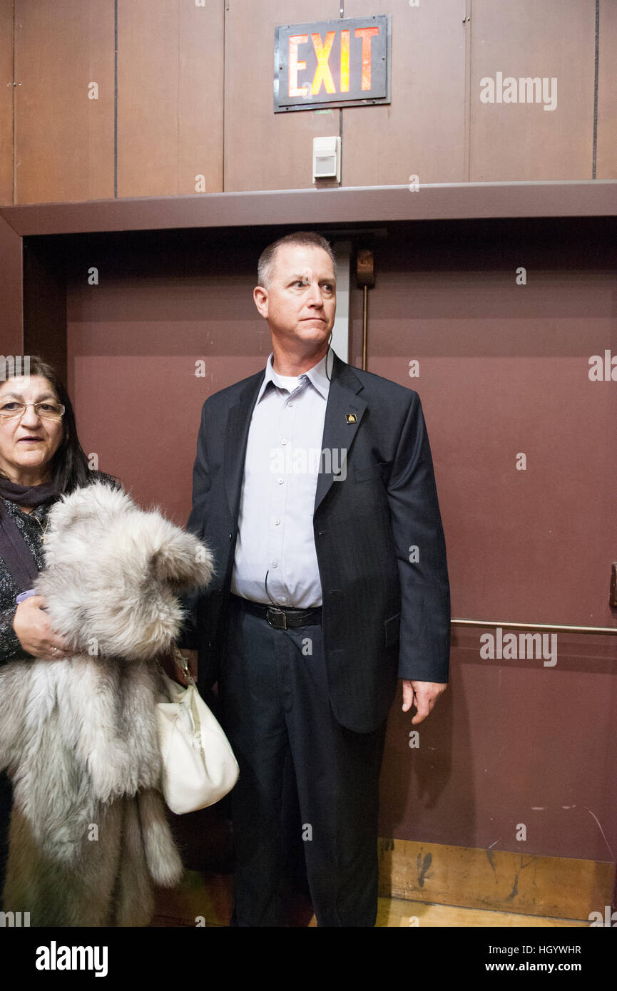 London, Ontario, Canada, 13 gennaio, 2017. Un agente di sicurezza sta di guardia di fronte a una porta di uscita nella sala degli alumni della London University of Western Ontario, dove il primo ministro del Canada, stava partecipando a un municipio Q&A. Londra è stata quella del primo ministro si ferma come parte del suo cross-country tour. Credito: Rubens Alarcon/Alamy Live News Foto Stock