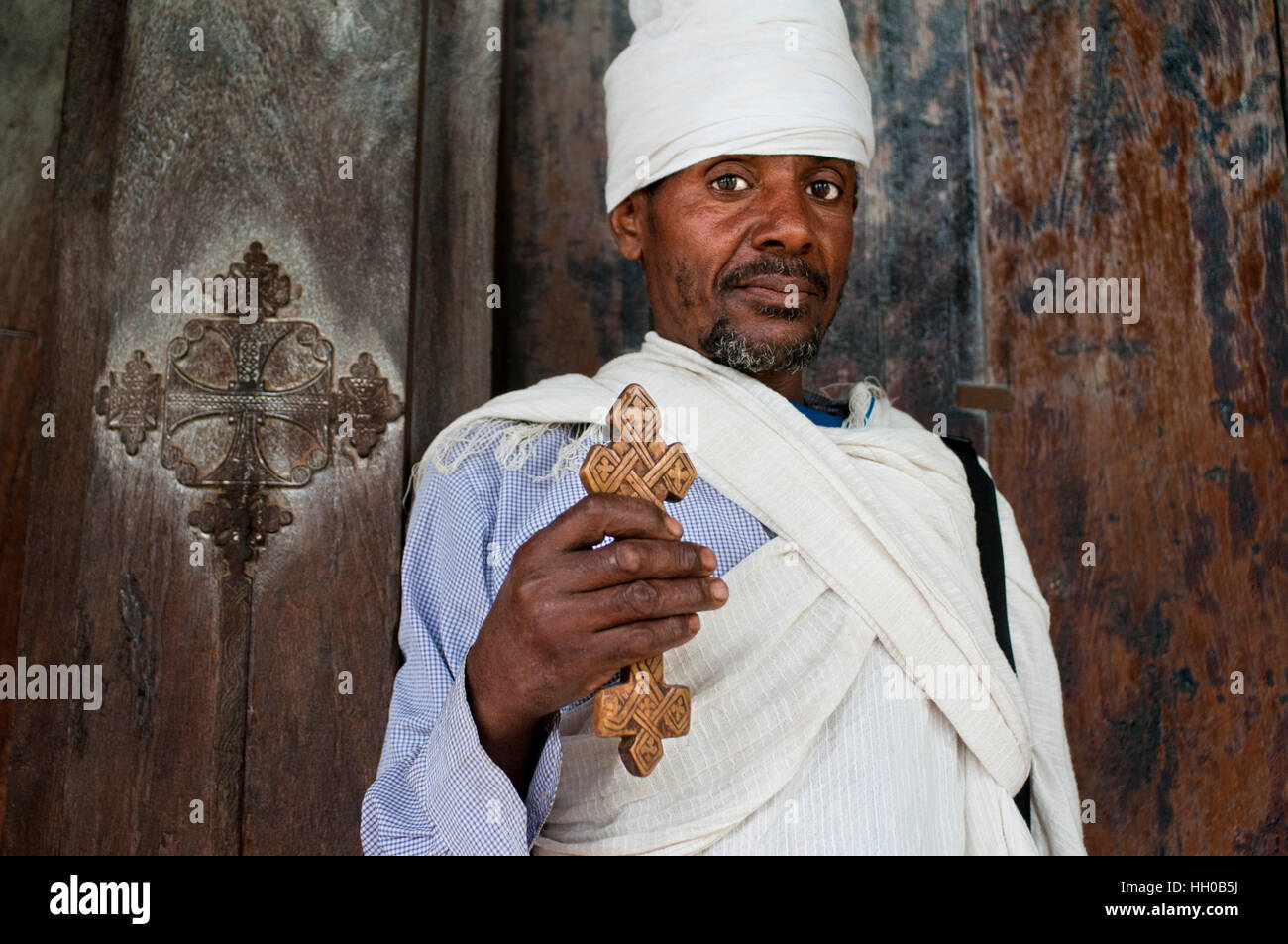 Bet Maryam monastero, il Lago Tana, Bahir Dar, Etiopia. Un sacerdote pone maestosamente con la sua croce alla porta di Birgida Maryam monastero in uno dei Foto Stock