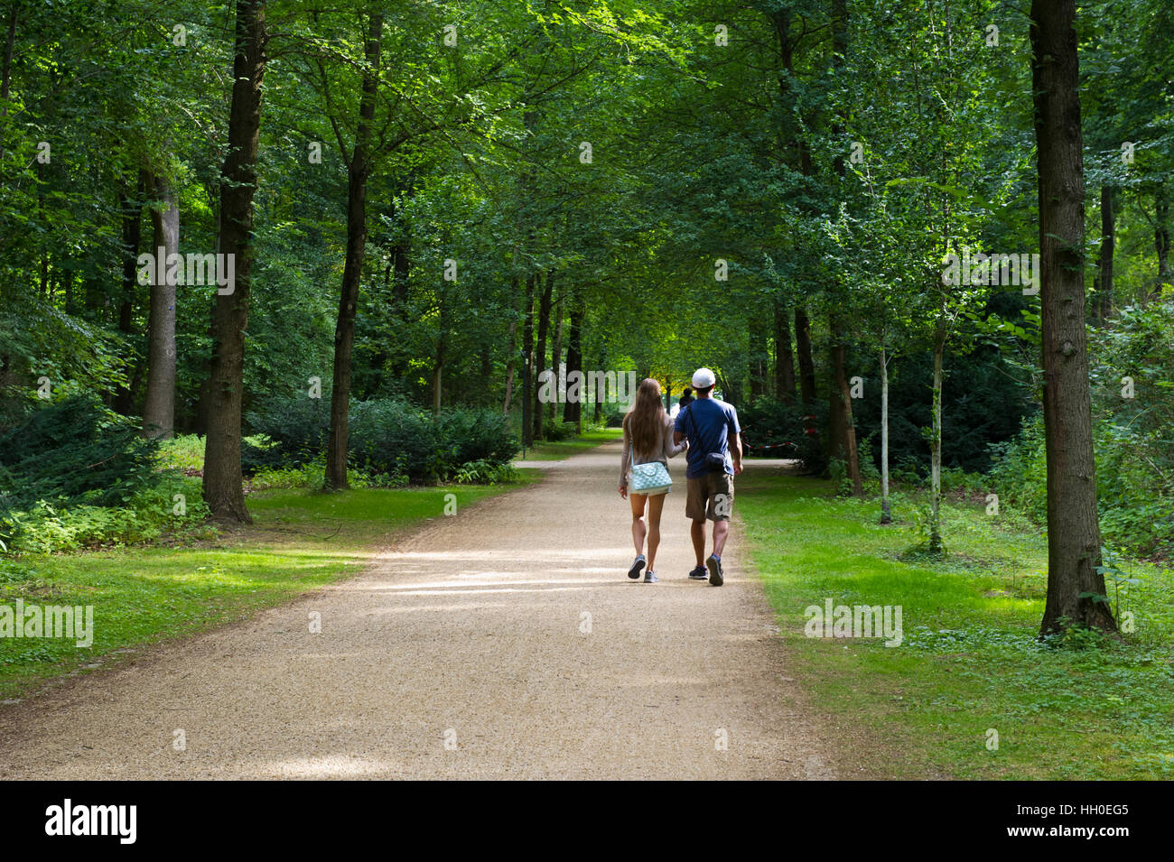 Una giovane coppia a piedi lungo il sentiero nel Tiergarten inter City Park a Berlino, Germania. Foto Stock