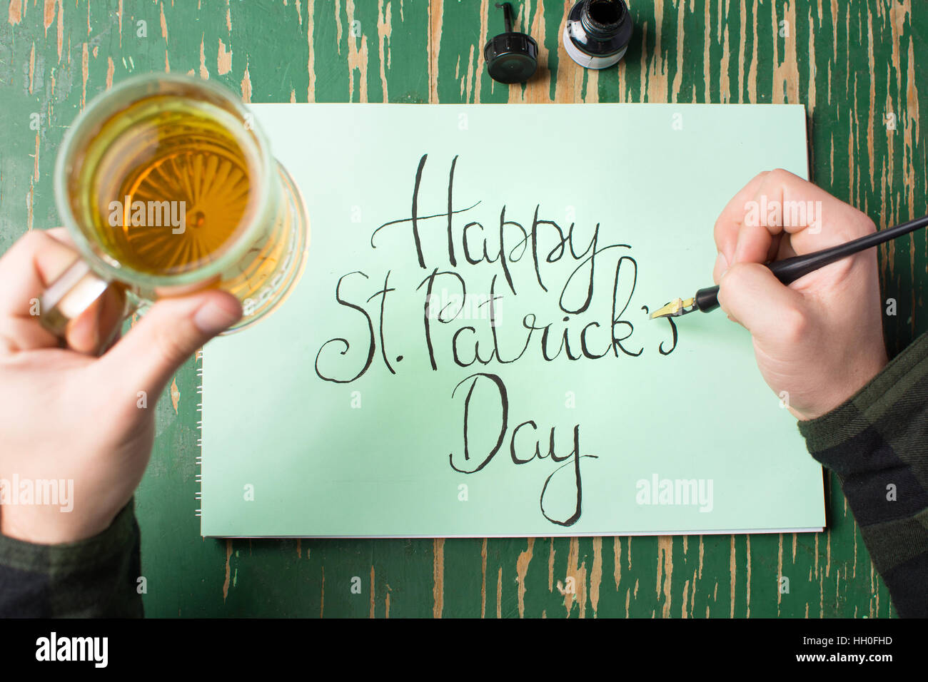 L'uomo con una birra con felice St Patrick giorno scheda di calligrafia Foto Stock