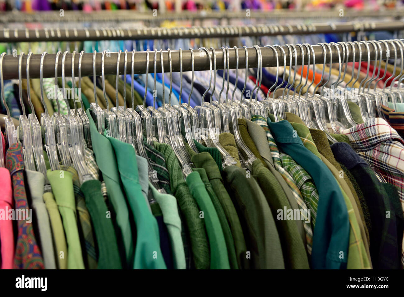 Rack di colorate magliette di colore verde in vendita nel negozio Foto Stock
