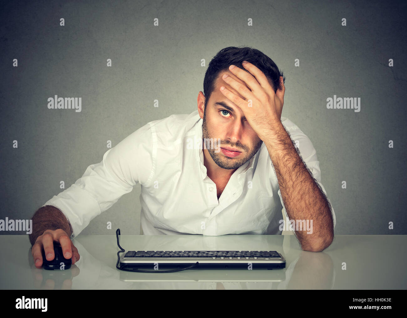 Disperata ha sottolineato giovane azienda dipendente che lavora sul computer Foto Stock