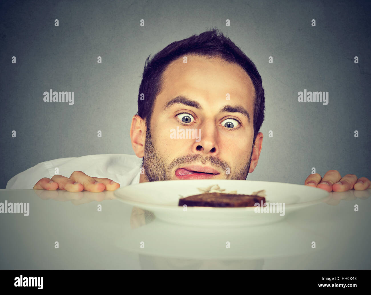 Uomo affamato craving cibo dolce Foto Stock