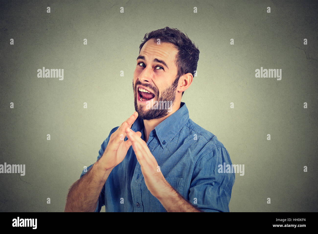 Arrabbiato pazzo furioso uomo alzando le mani in aria attacco con il karate chop isolati uno sfondo grigio. Emozione negativa espressione facciale Foto Stock