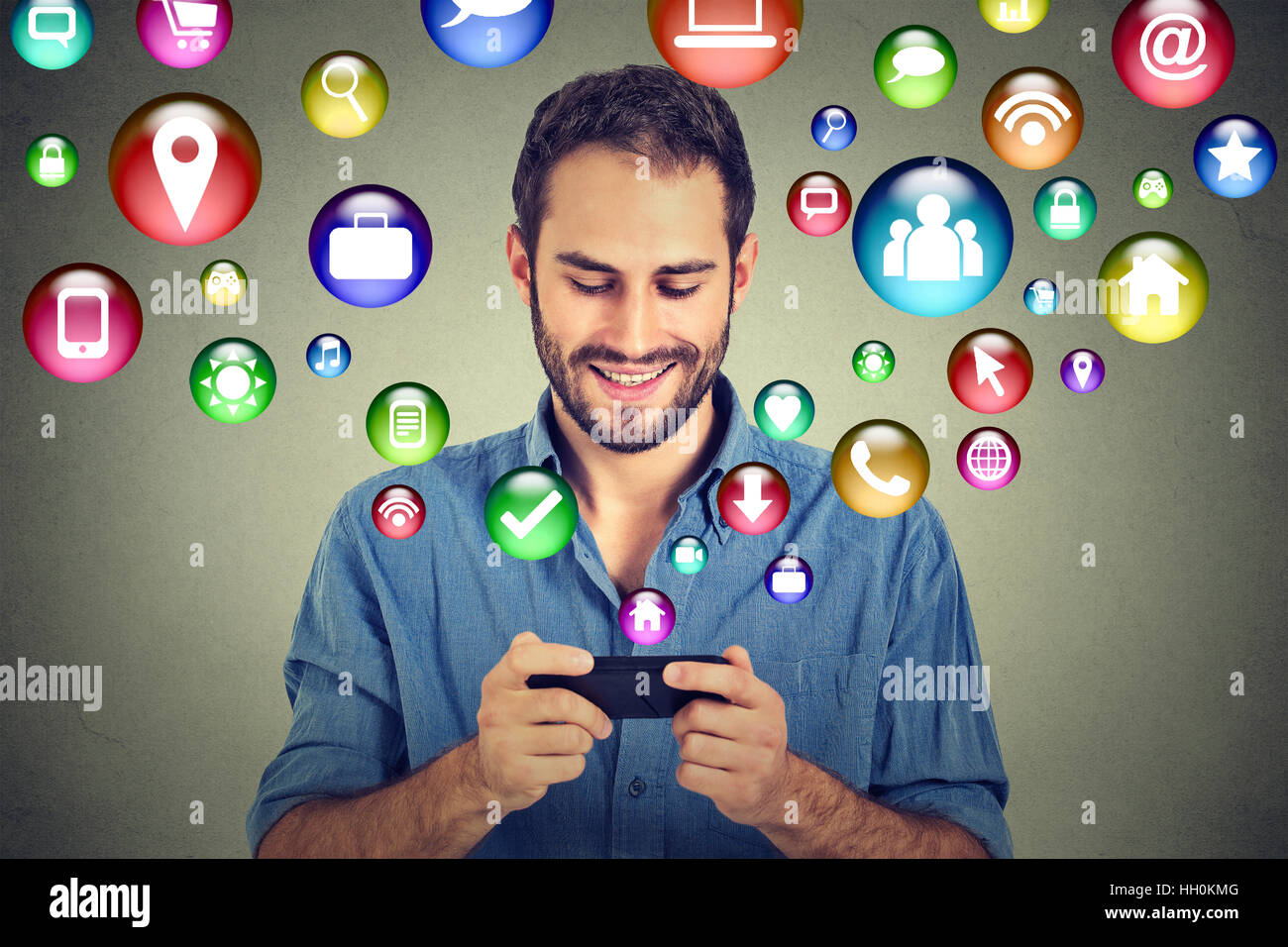 La tecnologia di comunicazione mobile phone high tech. Felice l'uomo utilizzando messaggi di testo sullo smartphone social media le icone delle applicazioni di volare Foto Stock