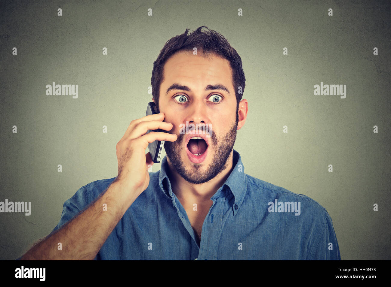 Scioccato uomo parlando al telefono cellulare Foto Stock