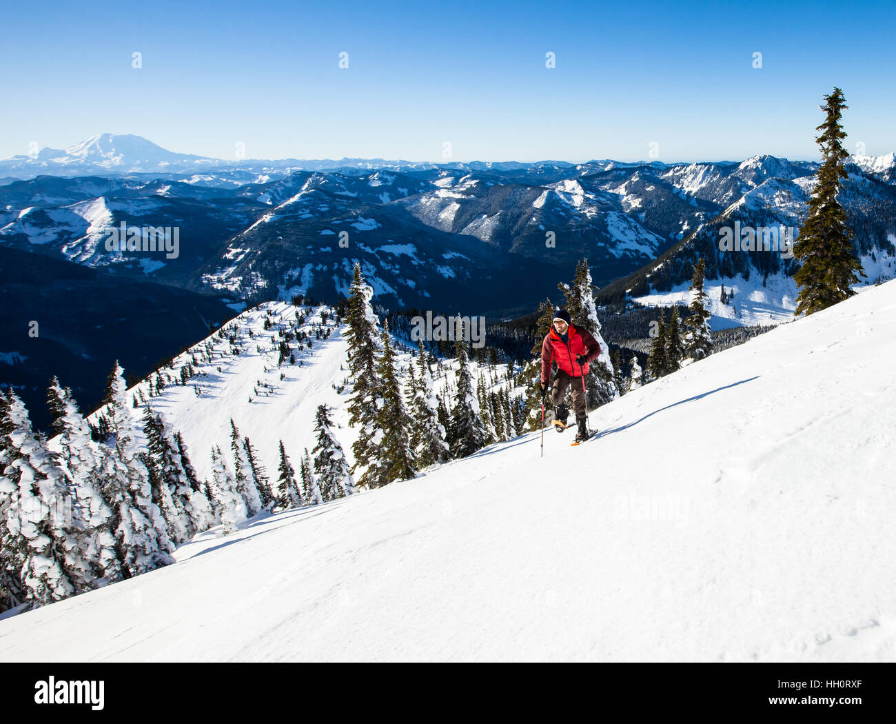 Un uomo con le racchette da neve fino a monte nel North Cascades montagne dello Stato di Washington Foto Stock