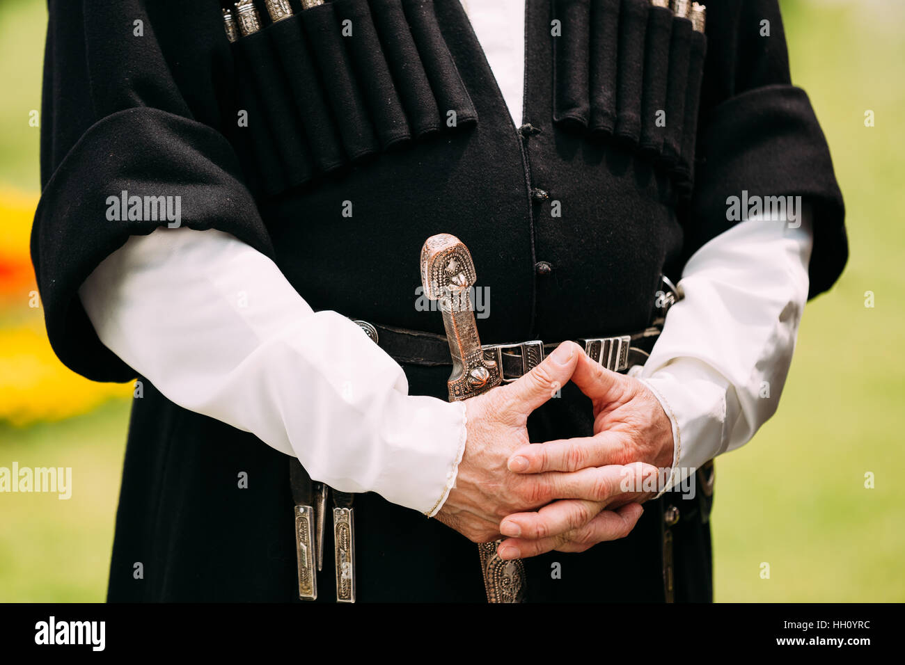 Chiudere fino a mani di un anziano uomo Georgiano in vestiti nazionali. La cultura del Paese Georgia. Sulla sua cintura pugnale appeso. Argento con cinghia di un'arma, un pugnale Foto Stock