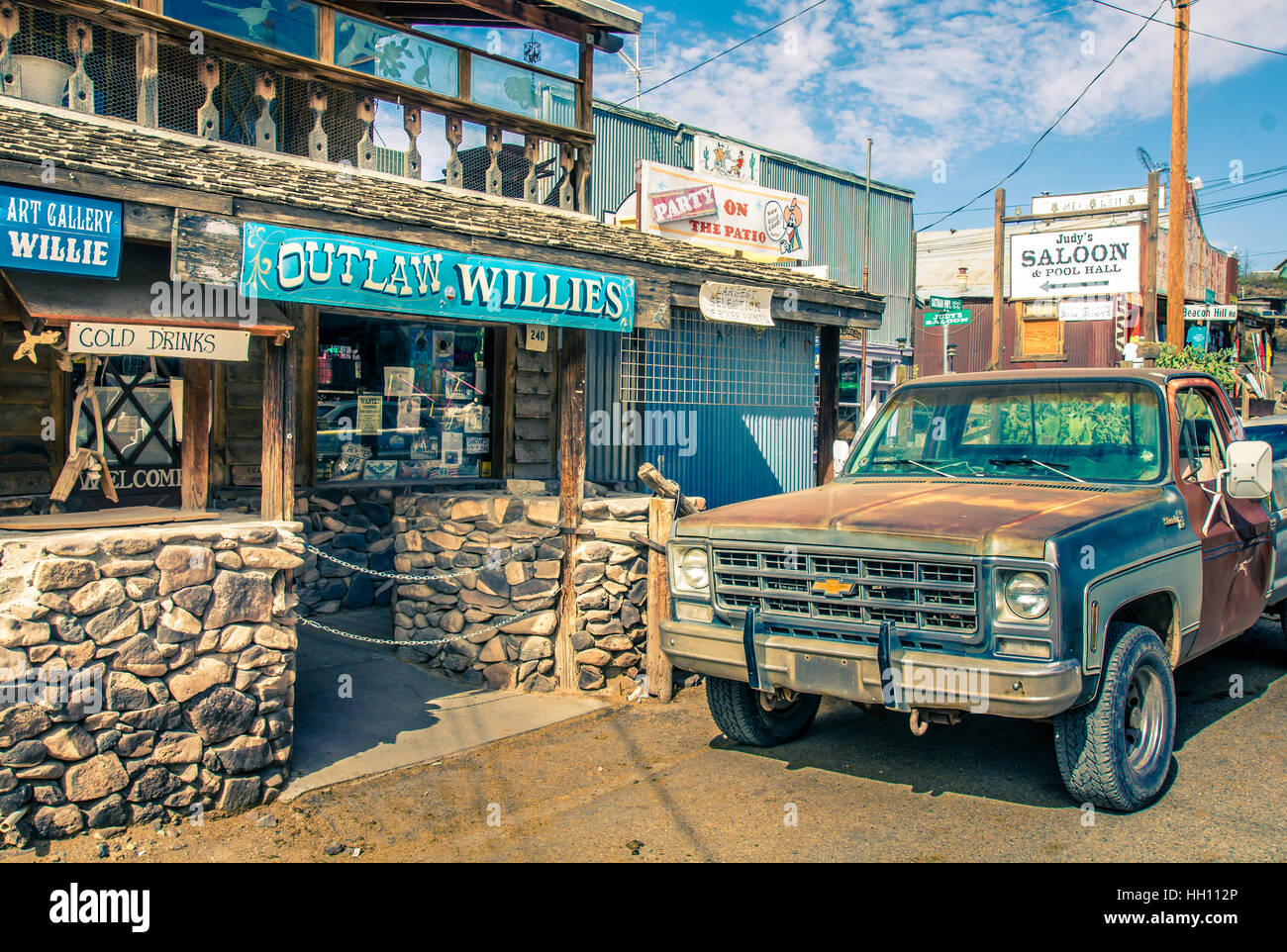 Moderno ovest selvaggio scenario in Oatman Arizona con i negozi per turisti e vecchio arrugginito ritiro auto in Oatman. Immagine in colori Vintage Look Foto Stock