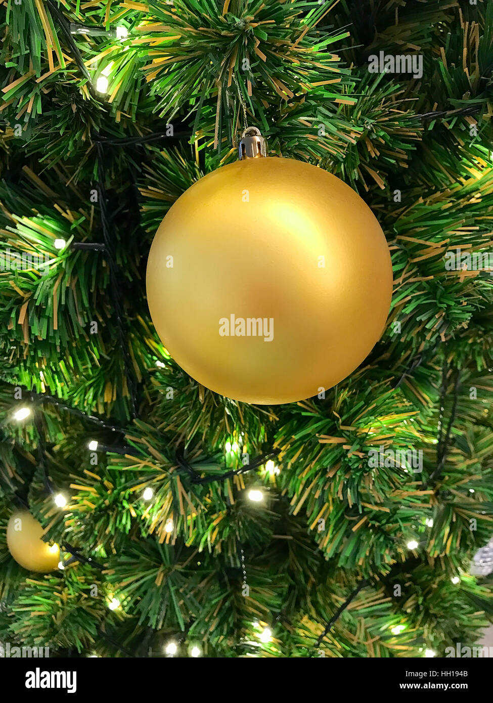 Sfera oro appeso su albero di Natale per la celebrazione Foto Stock