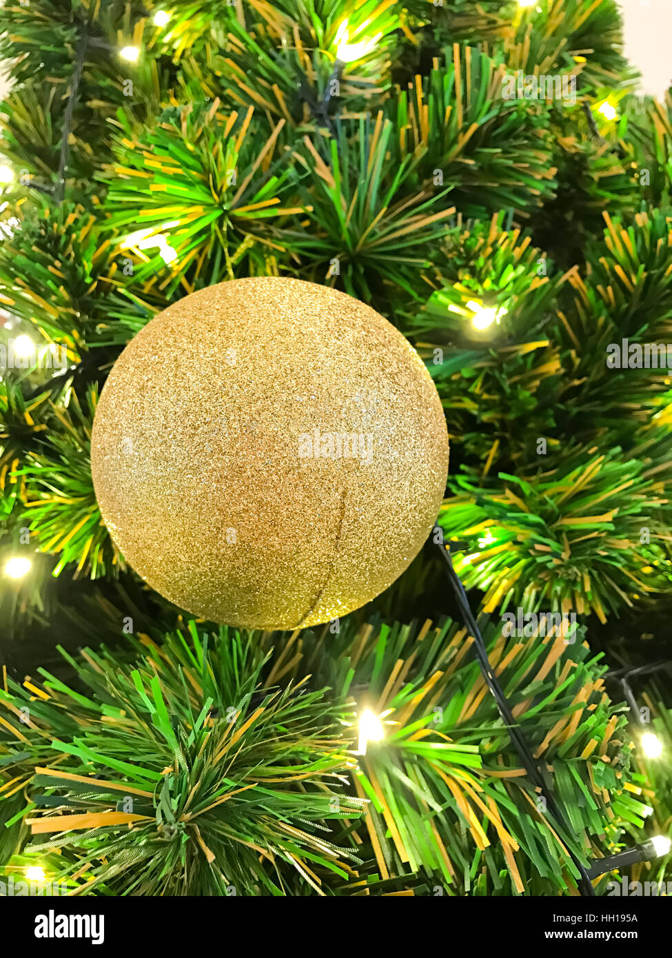 Sfera oro appeso su albero di Natale per la celebrazione Foto Stock