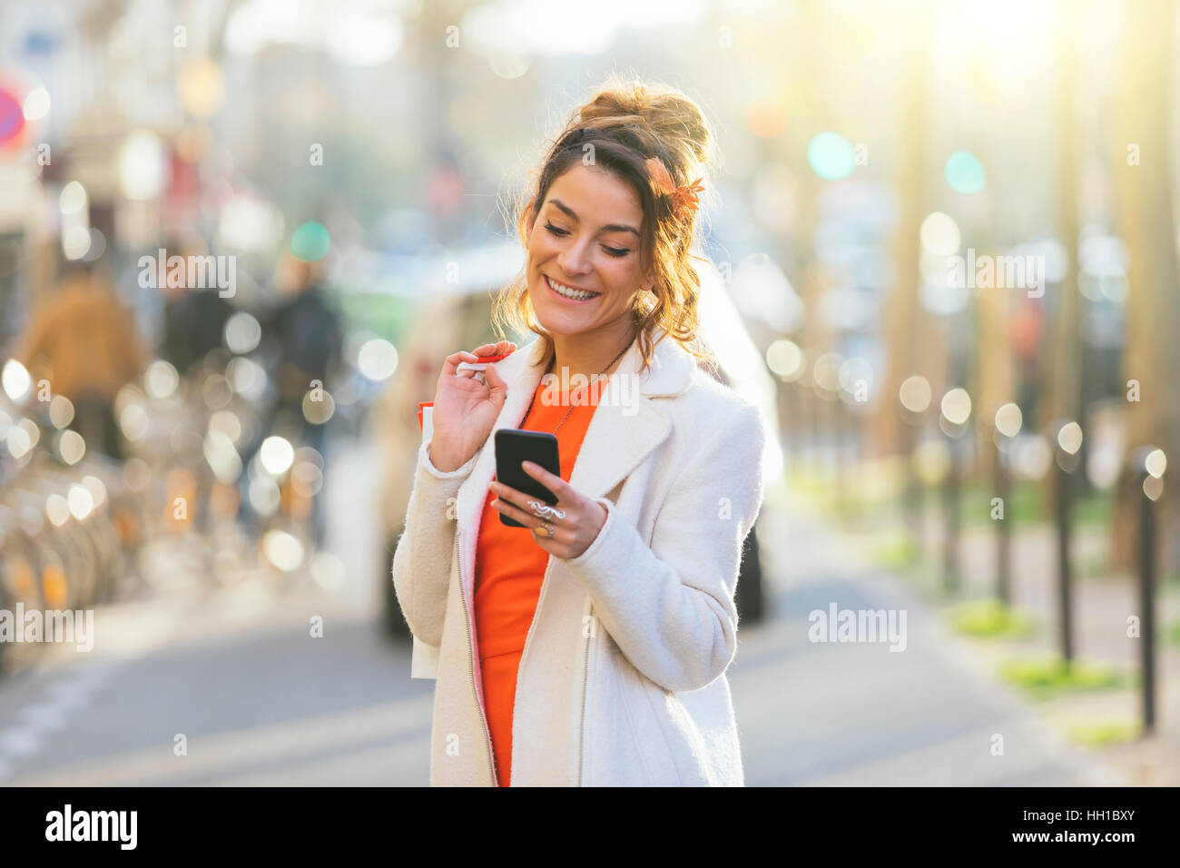 Parigi, Donna utilizzando smart phone in strada Foto Stock