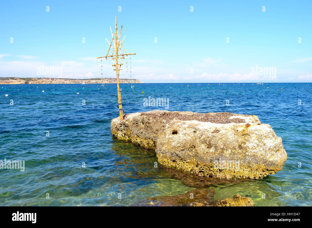 Croce di legno su una roccia in una spiaggia di Malta Foto Stock