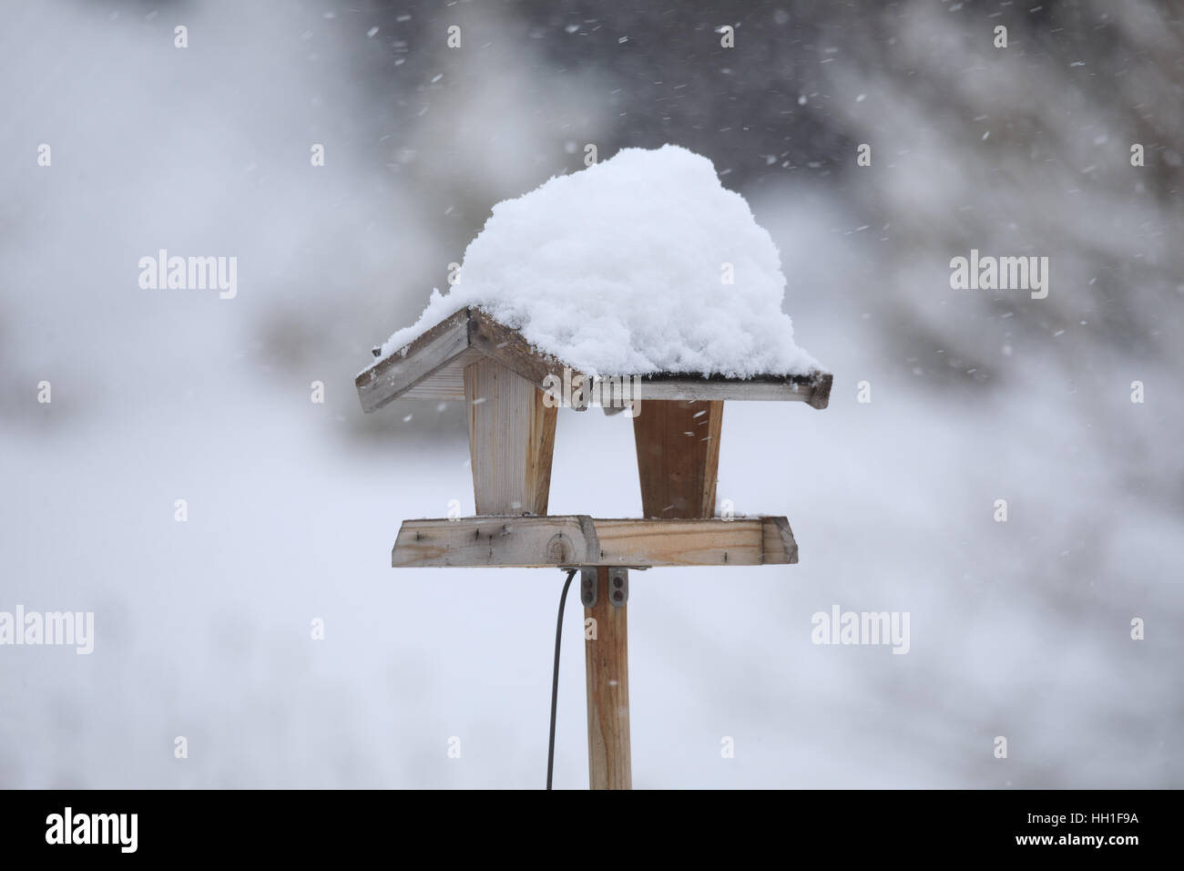 In casa semplice legno Bird Feeder, birdhouse installato su giardino d inverno in giornata nevosa Foto Stock