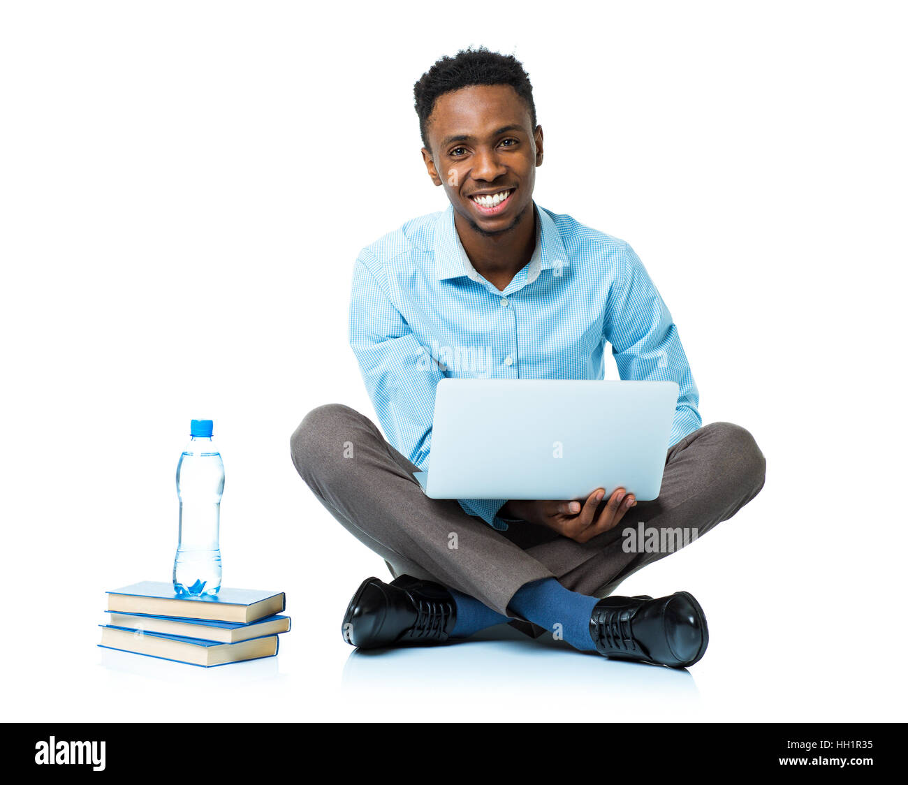 Felice African American college studente seduto con il portatile su sfondo bianco Foto Stock