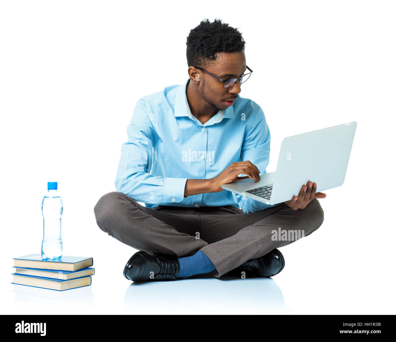 Felice African American college studente seduto con il portatile su sfondo bianco Foto Stock