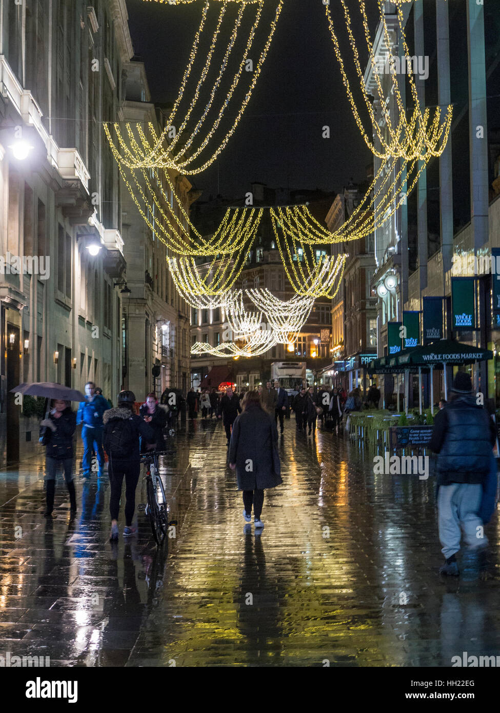 Shoppers brave la pioggia per lo shopping di Natale nel West End di Londra Foto Stock