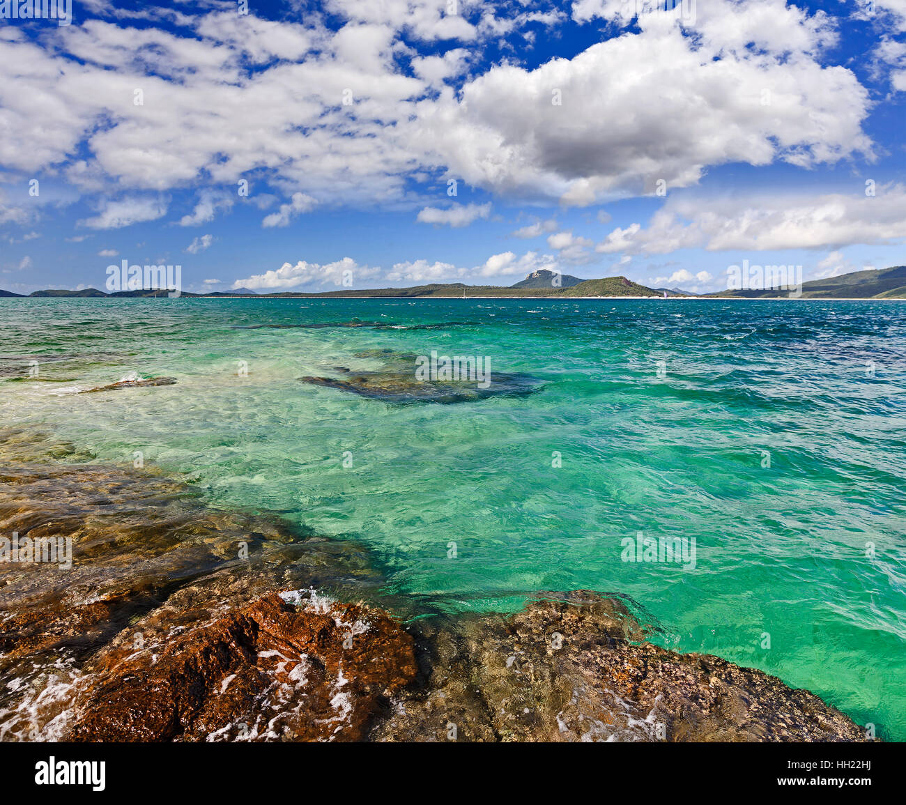 Pulire corallo Verde oceano mare tra isole Whitsunday a vivere Coral Island su una soleggiata giornata estiva. Foto Stock