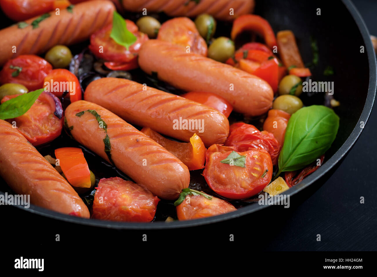 Salsicce alla griglia con verdure in uno stile Greco sulla teglia. Foto Stock