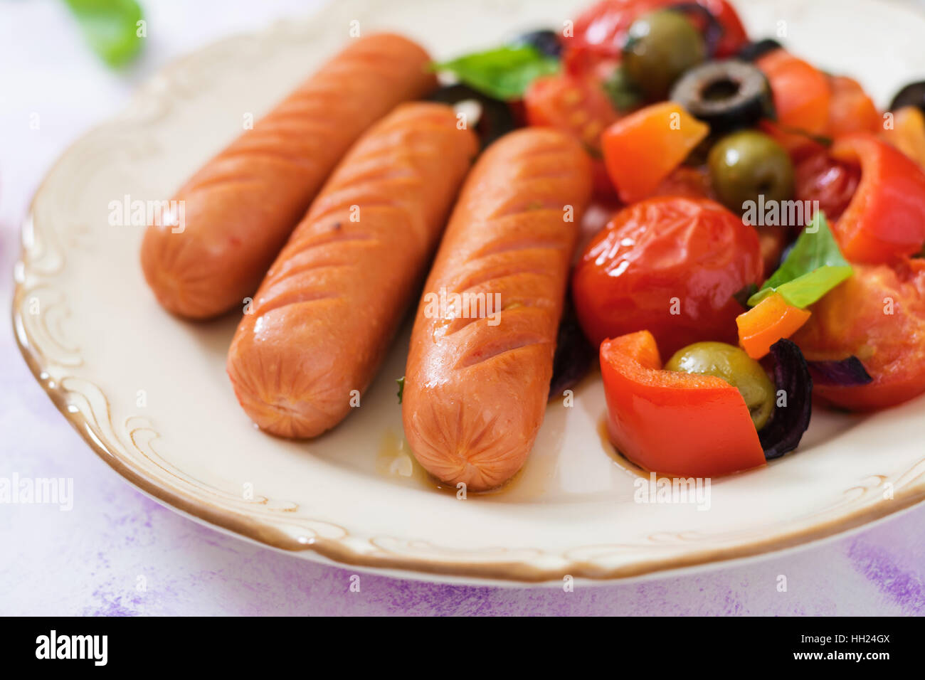 Salsicce alla griglia con verdure in uno stile Greco sulla piastra. Foto Stock